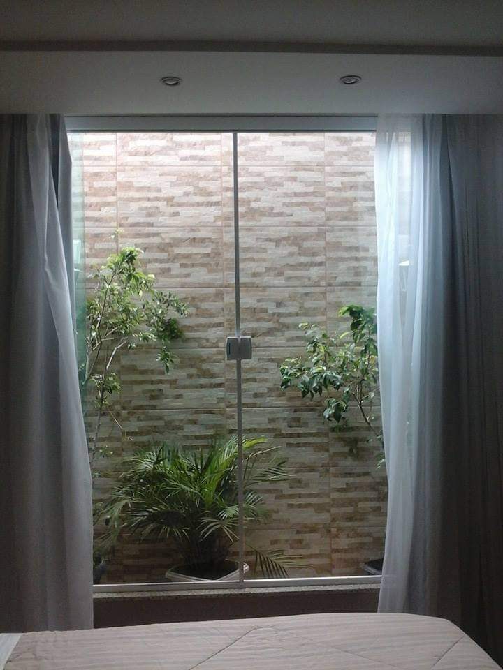 Porta de vidro de correr instalada com vista para jardim